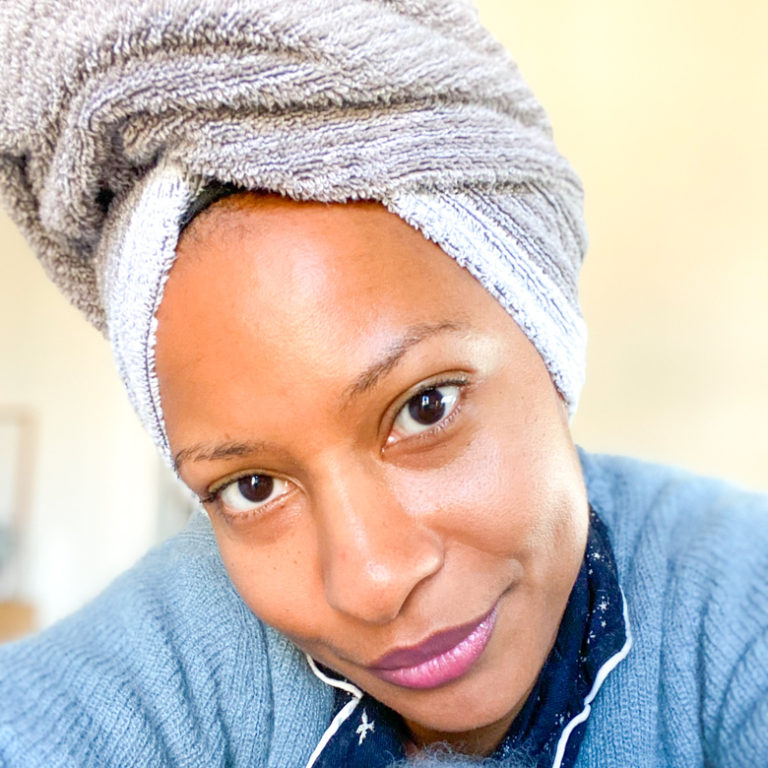 image of brown woman with hair wrapped in towel sharing best organic, vegan, and cruelty free skincare brands